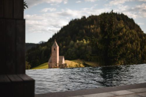 a church on the shore of a body of water at Miramonti Boutique Hotel in Avelengo