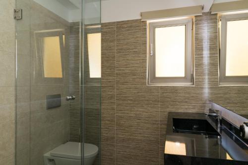 a bathroom with a toilet and a glass shower at Platanias Aetheras Beach in Plataniás