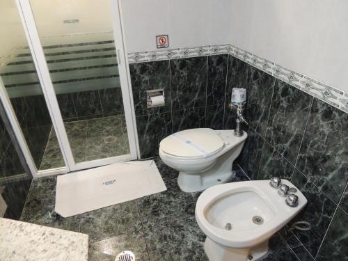 a bathroom with a toilet and a shower and a sink at Lisboa Hotel in Mexico City