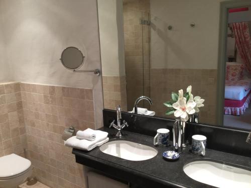 a bathroom with two sinks and a toilet and a mirror at B&B Auberge De Klasse in Veurne