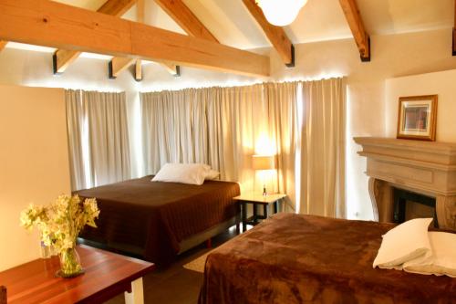 a hotel room with two beds and a fireplace at Casa Toscana Bed & Breakfast in San Miguel de Allende