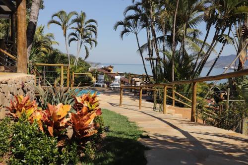 a person taking a picture of the ocean from a resort at Pousada Altamira in Ilhabela