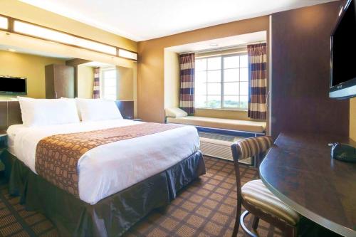 a hotel room with a large bed and a table at Microtel Inn & Suites by Wyndham Macon in Macon