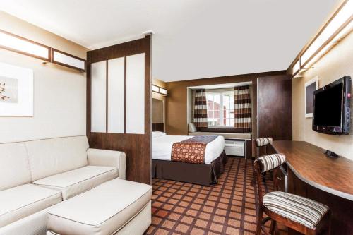 a hotel room with a bed and a desk at Microtel Inn & Suites by Wyndham Macon in Macon