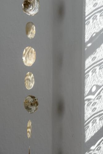 a group of coins hanging on a wall at Al vicolo del Gallo in Varallo