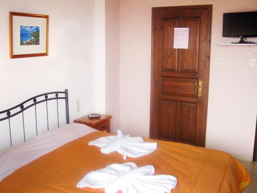 a bedroom with a bed with white towels on it at Katerina Apartments in Agios Ioannis Pelio