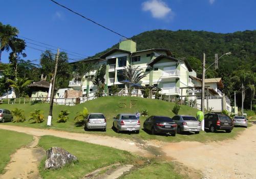 a group of cars parked in front of a house at Solar do Forte Flats in Ubatuba