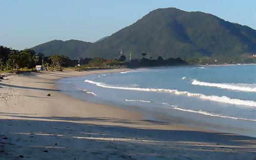 a view of a beach with mountains in the background at Solar do Forte Flats in Ubatuba