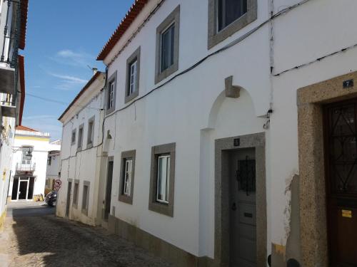 a white building with a door on a street at A Casa do Mestre in Évora