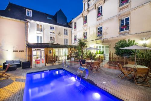 a swimming pool in the middle of a courtyard with buildings at Grand Hôtel du Luxembourg & Spa in Bayeux