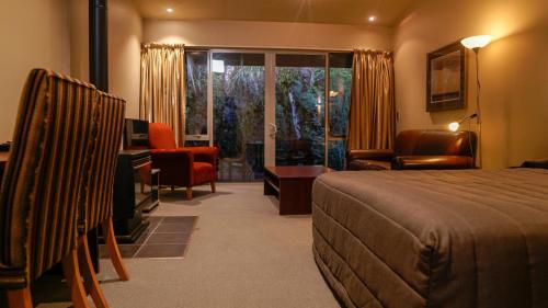 Habitación de hotel con cama y sala de estar. en Punga Grove en Franz Josef