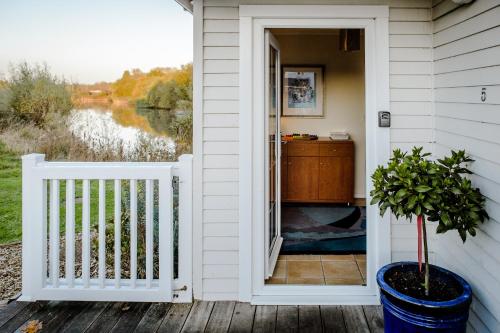a door to a porch with a view of the water at Windrush Turret Lodge in South Cerney