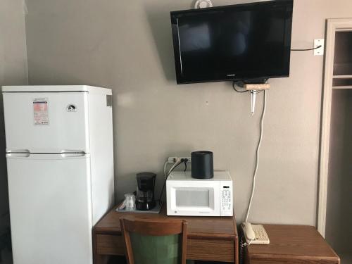 a kitchen with a table with a microwave and a refrigerator at Cooper Motel Tuscola in Tuscola