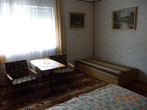 バラトンボグラールにあるApartment in Balatonboglar/Balaton 18183のベッド、テーブル、椅子が備わる客室です。
