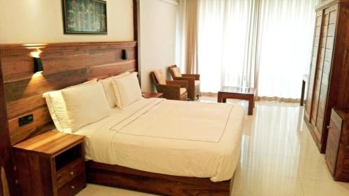 a bedroom with a large bed with a wooden headboard at Lakewood Residence in Kandy