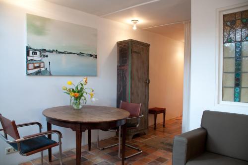 Cette chambre comprend une table, des chaises et un vase de fleurs. dans l'établissement Kalkmarkt Suites, à Amsterdam