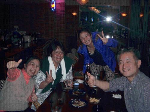 a group of people sitting around a table in a bar at Family Ryokan Kawakyu with Showa Retro, private hot spring in Ibusuki
