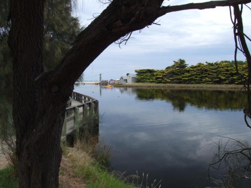 a body of water with trees and a boat at Lorne Coachman Inn in Lorne