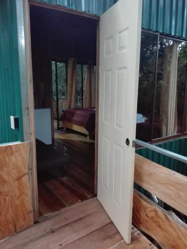 an open door in a room with a bedroom at The Green Tree Lodge in Monteverde Costa Rica