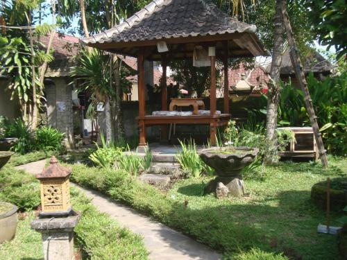 a garden with a gazebo and a bird bath at Gusti Home Stay Ubud in Ubud