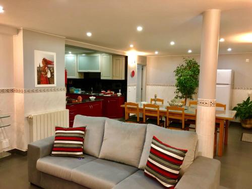 a living room and kitchen with a couch and a table at Casa Golfinho in Viana do Castelo
