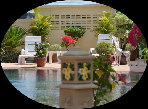 a view of a swimming pool with chairs and flowers at Baan Sabaijai Resort in That Phanom