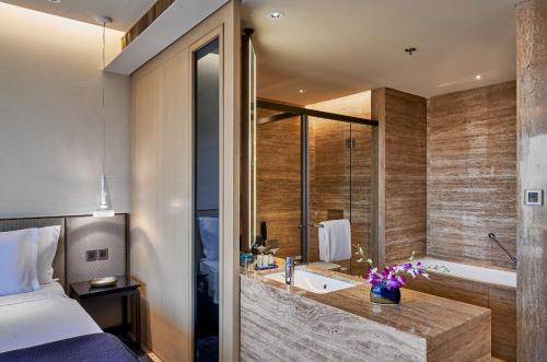a bathroom with a bed and a tub and a sink at The Den, Bengaluru in Bengaluru