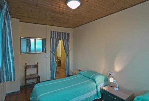 1 dormitorio con 1 cama azul y 1 silla en Hotel Firenze en Viareggio