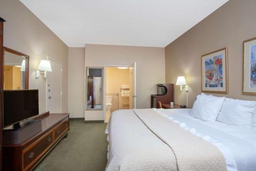 A bed or beds in a room at Days Inn by Wyndham Statesboro