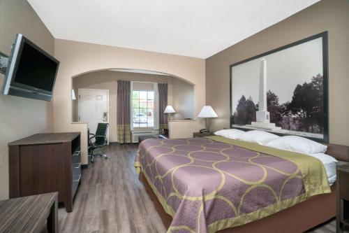 a hotel room with a bed and a flat screen tv at Super 8 by Wyndham Murfreesboro in Murfreesboro