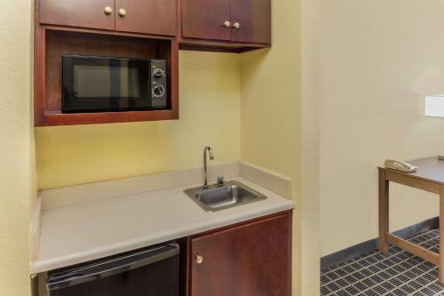 a small kitchen with a sink and a microwave at Days Inn & Suites by Wyndham Union City in Union City