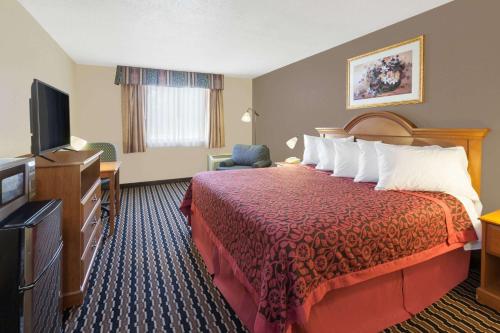 a hotel room with a bed and a flat screen tv at Days Inn by Wyndham Albion in Albion