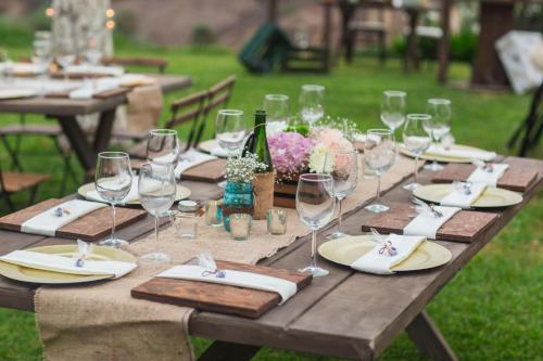 a wooden table with wine glasses and napkins on it at Real del Mar Golf Resort in Tijuana