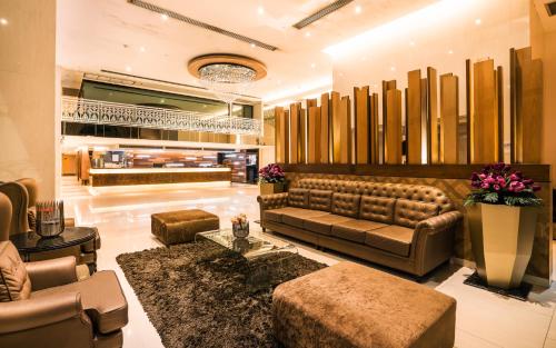 a lobby with a leather couch and tables and chairs at Grand Lord Boutique Hotel -Srinakarin in Bangna