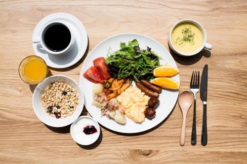 una mesa con un plato de comida y una taza de café en Hotel Daiei Masuda en Masuda