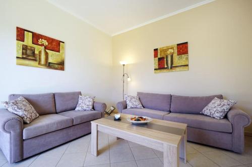 a living room with two couches and a coffee table at Maria's Garden in Galatás