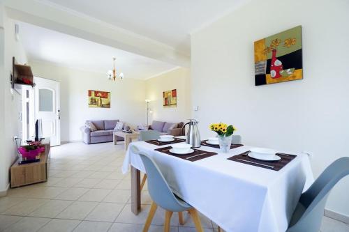 a dining room and living room with a table and chairs at Maria's Garden in Galatás