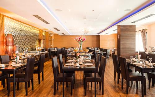 a restaurant with tables and chairs in a room at Grand Lord Boutique Hotel -Srinakarin in Bangna