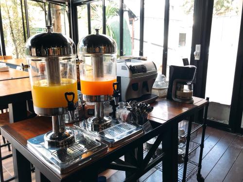 a juicer with two glasses of orange juice at The Nimman Hotel - SHA Plus in Chiang Mai