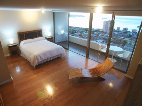 a bedroom with a bed and a view of a city at Alluring View at Valparaiso departamento in Valparaíso