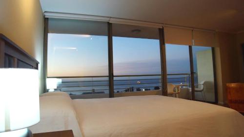 a bedroom with a bed and a large window at Alluring View at Valparaiso departamento in Valparaíso