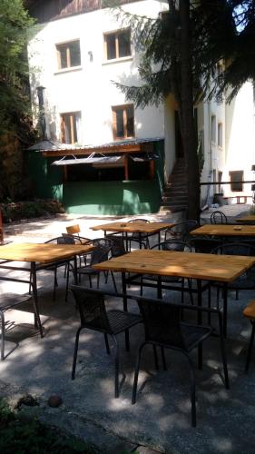 a group of wooden tables and chairs in front of a building at Хижа Люляка in Kostinbrod