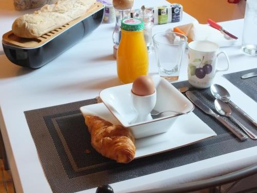 une table avec une assiette de nourriture avec un œuf dessus dans l'établissement Country B&B, à Saint-Pierre-dʼEyraud