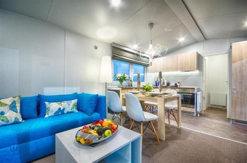 a living room with a blue couch and a table at Ferienhaus Leipzig am Schladitzer See in Rackwitz