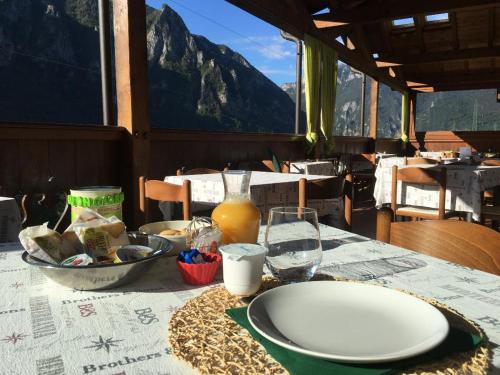 una mesa con un plato de comida y un vaso de zumo de naranja en albergo panoramico, en Lenna