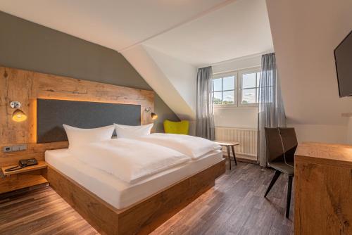 a bedroom with a large bed and a table at Hotel Pfeffermühle in Siegen