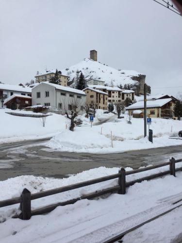 a street covered in snow with houses in the background at Attika Wohnung 7546 Ardez in Ardez