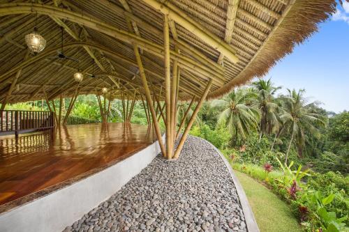 a large building with a roof with a walkway at Amori Villas in Ubud