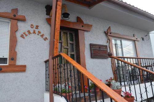 a house with a wooden door and a balcony at Os Piratas in Charneca