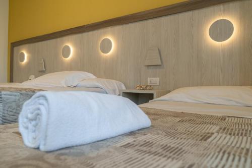 a bedroom with two beds with white towels on them at Hotel Continental in Tortoreto Lido
